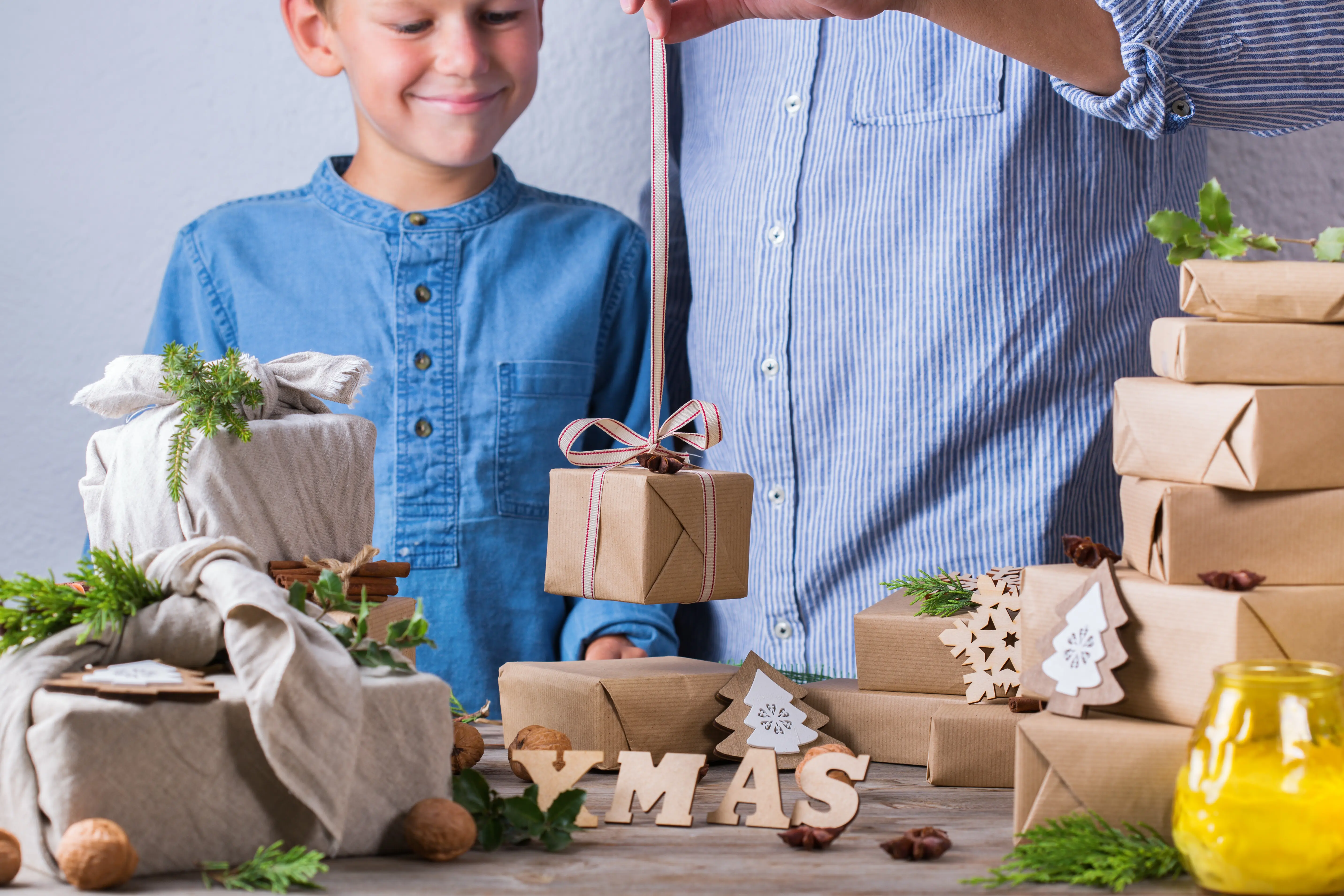 Zero-Waste-Weihnachtskonzept: Vater und Sohn packen Geschenke ein.