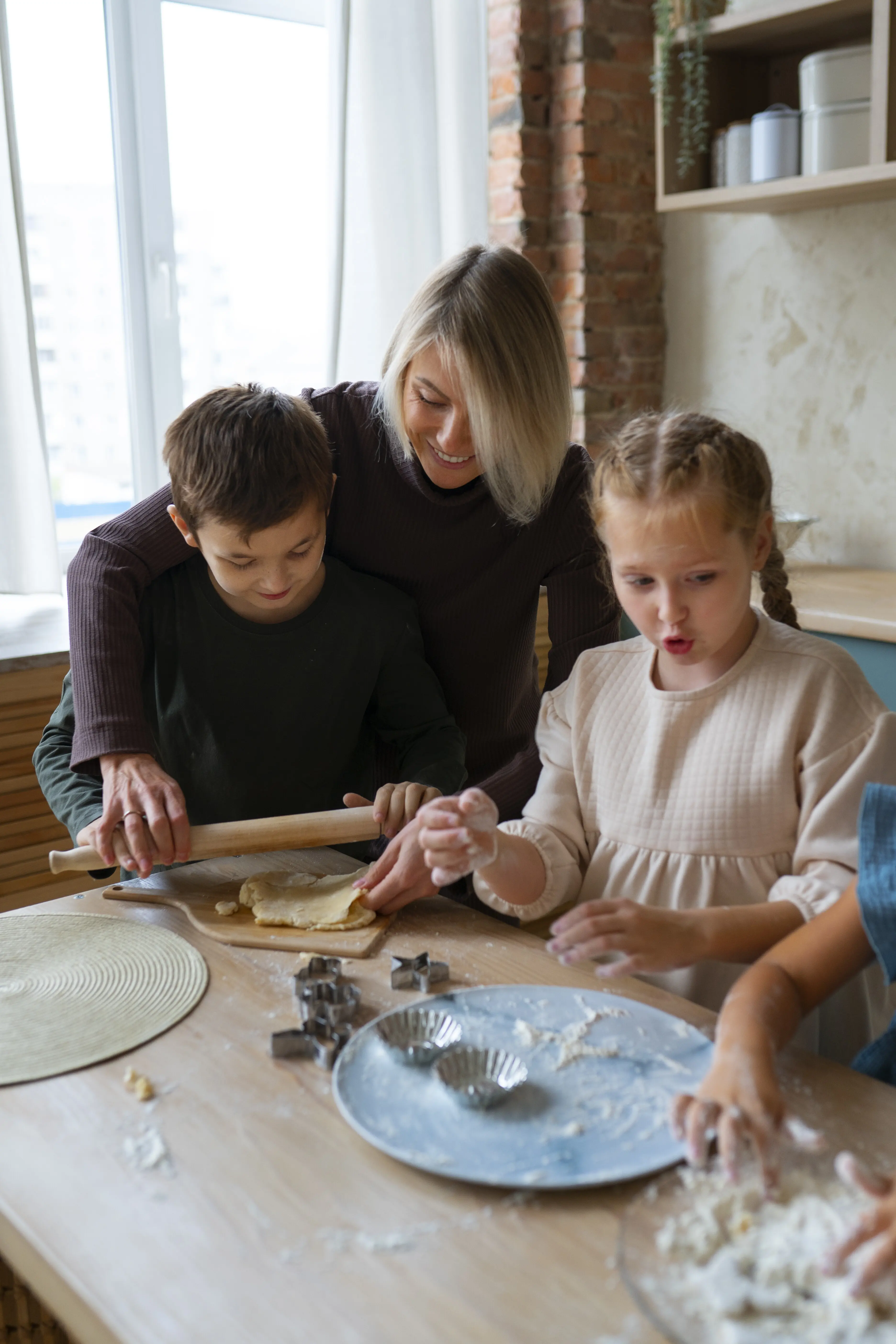 Frau hilft Kindern beim Kochen, halbnahe Einstellung.