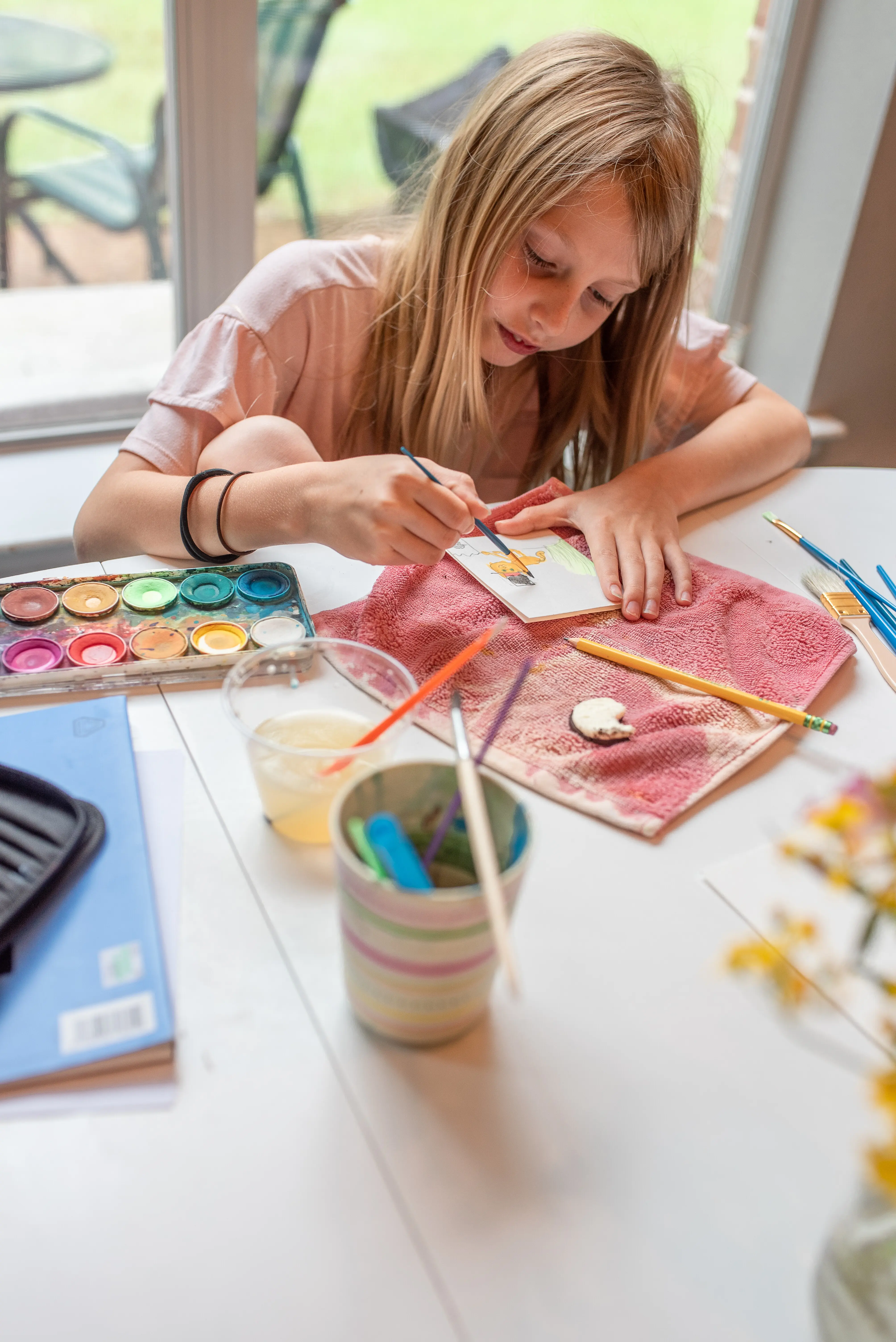 Porträt einer jungen Frau, die am Tisch ein Mobiltelefon benutzt.