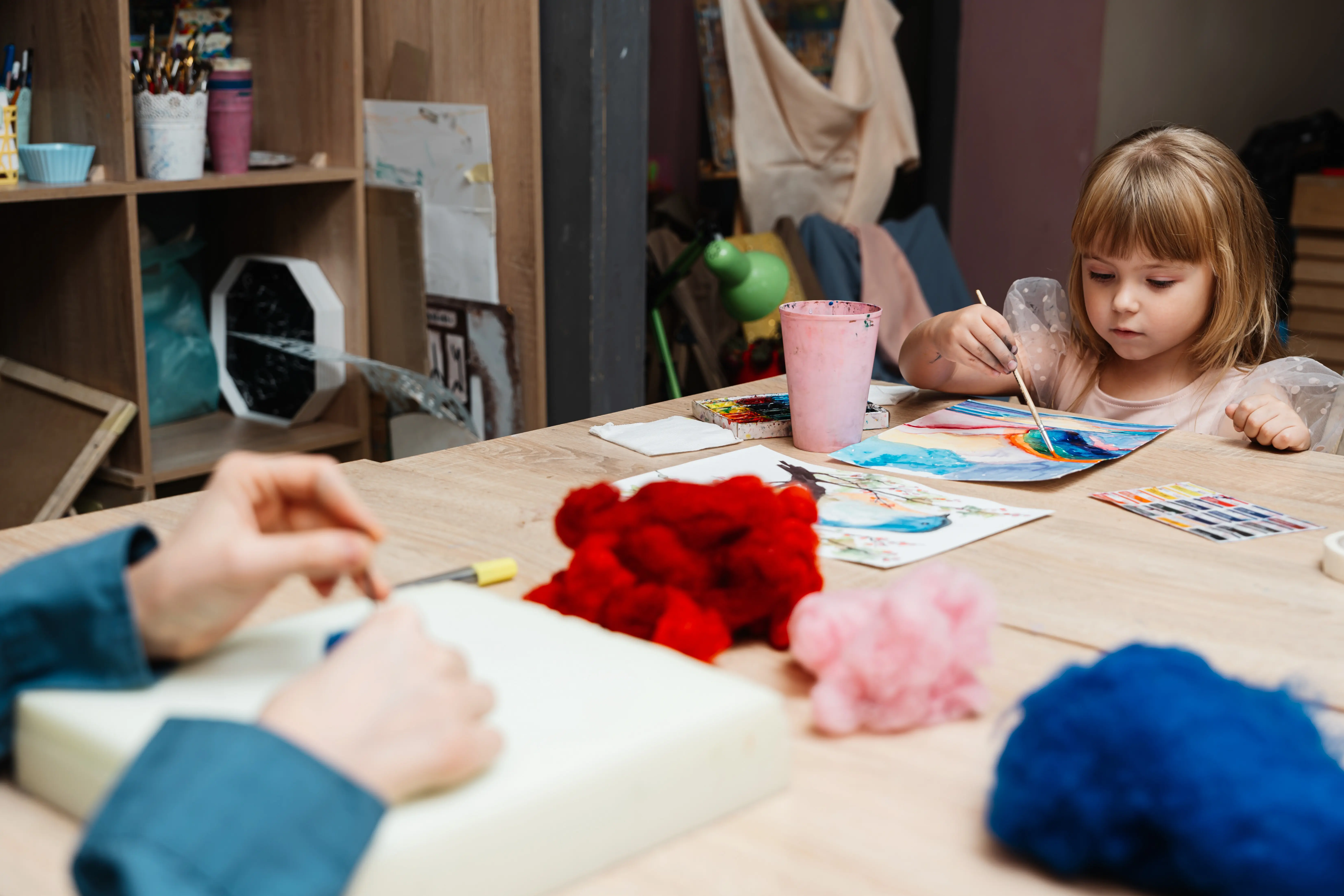 Ein Kind beschäftigt sich mit kreativem Malen in einem gemütlichen Kunststudio.